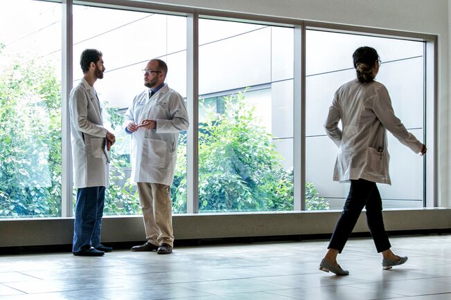 Three physicians in a hallway.